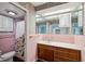 Retro bathroom boasts a vanity with a large mirror, and a shower with a floral curtain at 3906 Versailles Dr, Tampa, FL 33634