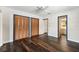 Bedroom with hardwood floors, neutral walls, and brown closet doors with blue trim at 3906 Versailles Dr, Tampa, FL 33634