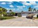 Charming single-story home with a well-manicured lawn, mature landscaping, and a boat parked in the driveway at 3906 Versailles Dr, Tampa, FL 33634