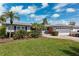 Charming single-story home with lush landscaping, a well-manicured lawn, and a two-car garage at 3906 Versailles Dr, Tampa, FL 33634