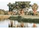 Lush green golf course with mature trees, a serene pond, and a blue flag marking the hole's location at 3906 Versailles Dr, Tampa, FL 33634