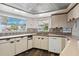 Traditional kitchen featuring tile backsplash, laminate countertop, wood cabinets, and stainless sink at 3906 Versailles Dr, Tampa, FL 33634