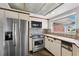 Kitchen features stainless steel appliances, tiled backsplash, wood cabinets, and bright natural light at 3906 Versailles Dr, Tampa, FL 33634
