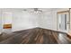 Bright living room featuring dark wood floors, a ceiling fan, and a glass door at 3906 Versailles Dr, Tampa, FL 33634