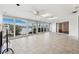 Bright living room with tile flooring, ceiling fans, and sliding glass doors overlooking the waterfront at 3906 Versailles Dr, Tampa, FL 33634