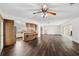 Spacious living area with dark wood floors, ceiling fan, and kitchen view at 3906 Versailles Dr, Tampa, FL 33634