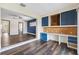 Living room with hardwood floors, a built-in desk, a water view, and a blue accent wall at 3906 Versailles Dr, Tampa, FL 33634