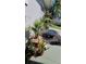 Landscaped outdoor shower area with river rock, potted plants, and a charming blue stone fire pit at 3906 Versailles Dr, Tampa, FL 33634
