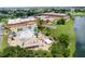An aerial view shows the clubhouse and pool area with lounge chairs and umbrellas at 411 Bloom Ct # 2A, Sun City Center, FL 33573