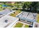 An aerial view of single-story units with a pond, tennis court, and landscape in the background at 411 Bloom Ct # 2A, Sun City Center, FL 33573