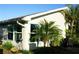 Well-maintained home exterior with lush landscaping, including tropical palm trees and large windows at 411 Bloom Ct # 2A, Sun City Center, FL 33573