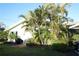 Home exterior with manicured lawn, palm trees, and paved patio area offering a tropical oasis at 411 Bloom Ct # 2A, Sun City Center, FL 33573