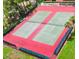 Aerial view of well-maintained tennis courts with nets and green and red painted surfaces at 411 Bloom Ct # 2A, Sun City Center, FL 33573