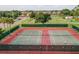 Community tennis courts featuring well-kept green and red playing surfaces, surrounded by greenery at 411 Bloom Ct # 2A, Sun City Center, FL 33573