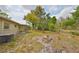 Spacious backyard with mature trees, fire pit, and privacy fence at 434 Pevetty Dr, Plant City, FL 33563