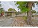 Charming single-story home featuring a covered carport and beautifully shaded front yard with mature trees at 434 Pevetty Dr, Plant City, FL 33563