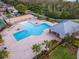 Aerial view of community pool, sand volleyball court, cabana, and lounge chairs at 4764 Chatterton Way, Riverview, FL 33578