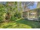 View of the lush backyard and screened porch at 4932 Wellbrook Dr, New Port Richey, FL 34653