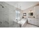 Modern bathroom with marble tiles, glass shower, soaking tub, and double vanity at 4932 Wellbrook Dr, New Port Richey, FL 34653