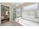 Bright bathroom featuring a glass shower, bathtub, and tile flooring at 4932 Wellbrook Dr, New Port Richey, FL 34653