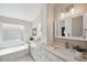 Stylish bathroom featuring a soaking tub, marble countertops, and a double vanity at 4932 Wellbrook Dr, New Port Richey, FL 34653