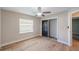 Bright bedroom features wood floors, ceiling fan, a window and a closet with black sliding doors at 4932 Wellbrook Dr, New Port Richey, FL 34653