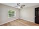 Bright bedroom featuring wood floors, a window and a ceiling fan at 4932 Wellbrook Dr, New Port Richey, FL 34653