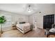 Bright bedroom featuring wood floors, ceiling fan, and a door leading to the bathroom at 4932 Wellbrook Dr, New Port Richey, FL 34653