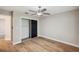 Bright bedroom features wood floors, closet with black sliding doors and a ceiling fan at 4932 Wellbrook Dr, New Port Richey, FL 34653