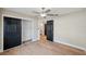 Bright bedroom features wood floors, a closet with black sliding doors and a ceiling fan at 4932 Wellbrook Dr, New Port Richey, FL 34653