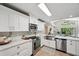 Bright kitchen with white cabinets, stainless appliances, and a stainless steel farmhouse sink at 4932 Wellbrook Dr, New Port Richey, FL 34653