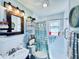Bright bathroom featuring a shower with a patterned curtain, a sink, and plants at 4976 12Th N Ave, St Petersburg, FL 33710