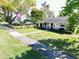 Landscaped front yard with mature tree, sidewalk and American flag at 4976 12Th N Ave, St Petersburg, FL 33710