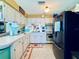 Functional kitchen featuring white cabinets, a black refrigerator, and a vintage stove at 4976 12Th N Ave, St Petersburg, FL 33710
