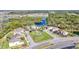 Aerial view of the community with homes surrounding a central green space and lake at 5016 Bella Armonia Cir, Wimauma, FL 33598