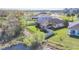 Aerial view of a fenced backyard with landscaping and a small pond nearby at 5016 Bella Armonia Cir, Wimauma, FL 33598