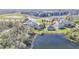 Back view of a home with a fenced yard overlooking a serene pond and lush greenery at 5016 Bella Armonia Cir, Wimauma, FL 33598