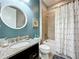 Stylish bathroom featuring a vanity with granite counters, tub with shower and coastal decor at 5016 Bella Armonia Cir, Wimauma, FL 33598