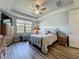 Cozy bedroom featuring tray ceiling, ceiling fan, a large window, and wood-look flooring at 5016 Bella Armonia Cir, Wimauma, FL 33598