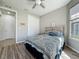 Cozy bedroom with wood-look floors, a queen-size bed, and plenty of natural light at 5016 Bella Armonia Cir, Wimauma, FL 33598