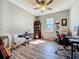 Home office with a musical instrument setup, ceiling fan, wood cabinet, and wood laminated floors at 5016 Bella Armonia Cir, Wimauma, FL 33598