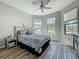 Bedroom with wood-look flooring, corner windows with blinds, and a ceiling fan at 5016 Bella Armonia Cir, Wimauma, FL 33598