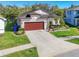 Charming single-story home with a well-manicured lawn, mature landscaping, and a spacious driveway at 5016 Bella Armonia Cir, Wimauma, FL 33598