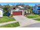 Charming single-story home with a well-manicured lawn, mature landscaping, and a spacious driveway at 5016 Bella Armonia Cir, Wimauma, FL 33598