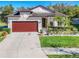 Inviting single-Gathering home with a well-kept lawn, landscaped flowerbeds, and a two-car garage at 5016 Bella Armonia Cir, Wimauma, FL 33598