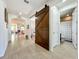 Hallway featuring a wooden barn door and access to a full bathroom at 5016 Bella Armonia Cir, Wimauma, FL 33598