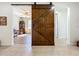 Hallway view, showing barn door separating the spaces between the living room and hallway at 5016 Bella Armonia Cir, Wimauma, FL 33598