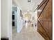 Hallway with neutral paint, light tile flooring, and views into the kitchen, dining and living areas at 5016 Bella Armonia Cir, Wimauma, FL 33598