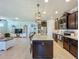 Open kitchen flows into the living room with an island, granite counters, stainless appliances and tile floors at 5016 Bella Armonia Cir, Wimauma, FL 33598