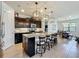 Kitchen with granite countertops, dark cabinetry, stainless appliances, and a large center island with seating at 5016 Bella Armonia Cir, Wimauma, FL 33598